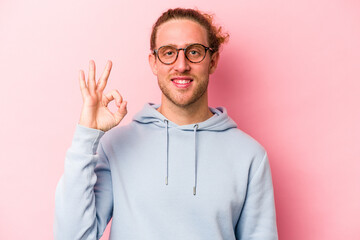 Young caucasian man isolated on pink background cheerful and confident showing ok gesture.