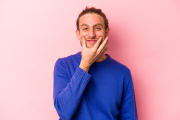 Young caucasian man isolated on pink background doubting between two options.
