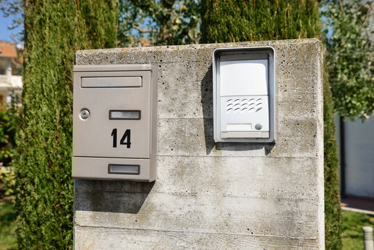 Mail box and intercom on grey concrete wall outdoors