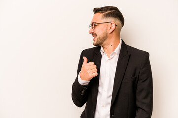 Business hispanic man isolated on white background points with thumb finger away, laughing and carefree.
