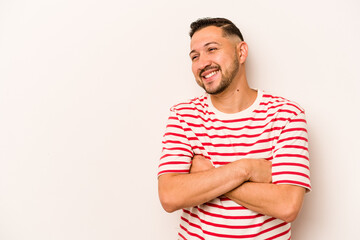 Young hispanic man isolated on white background smiling confident with crossed arms.