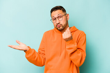 Young hispanic man isolated on blue background showing that she has no money.