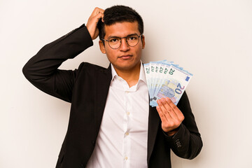 Young hispanic business man holding banknotes isolated on white background being shocked, she has remembered important meeting.