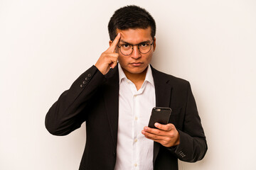 Young business hispanic man holding mobile phone isolated on white background pointing temple with finger, thinking, focused on a task.