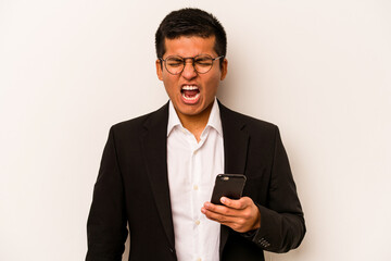 Young business hispanic man holding mobile phone isolated on white background screaming very angry and aggressive.
