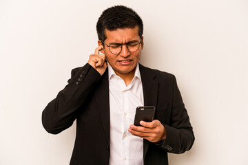 Young business hispanic man holding mobile phone isolated on white background covering ears with hands.