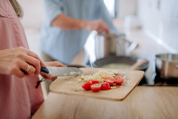 Happy senior couple cooking together at home, close-up.
