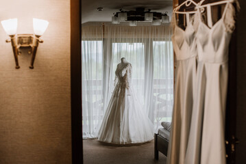 Stylish wedding dress on a mannequin in the morning by the window on the wedding day. Preparing for the wedding day