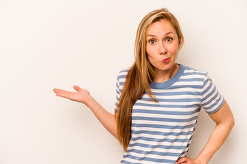 Young caucasian woman isolated on white background showing a copy space on a palm and holding another hand on waist.