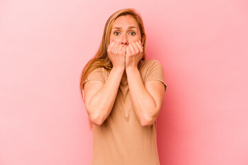 Young caucasian woman isolated on pink background biting fingernails, nervous and very anxious.