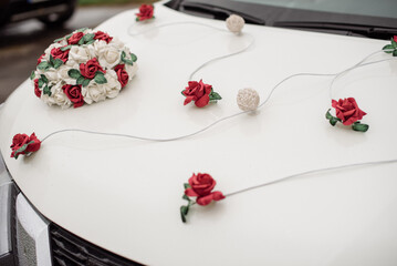 White car in a wedding procession beautifully decorated with flowers