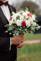 Groom holding beautiful white wedding bouquet. Closeup