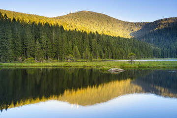 Fototapeta na wymiar Beautiful Small Arber lake in the Bavarian Forest at sunset. View to mount Großer Arber.