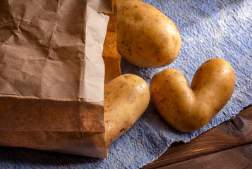 Heart shaped ugly potato on blue sackcloth