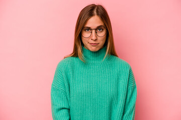 Young caucasian woman isolated on pink background sad, serious face, feeling miserable and...