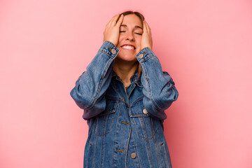 Young caucasian woman isolated on pink background laughs joyfully keeping hands on head. Happiness concept.