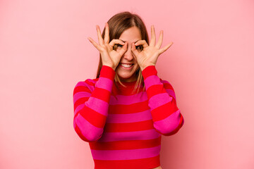 Young caucasian woman isolated on pink background excited keeping ok gesture on eye.