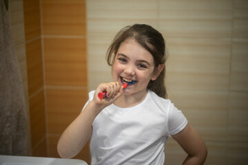 Szczęśliwa dziewczynka myjąca swoje zęby - obrazy, fototapety, plakaty
