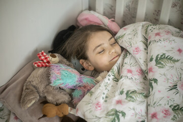 Młoda dziewczynka śpiąca w swoim łóżku
