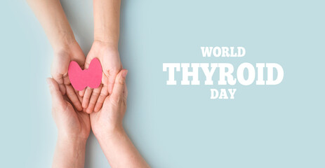 World Thyroid Day. Adult and children holding paper form of the thyroid gland on blue background. Problems with thyroid. Polycystic disease. World cancer day