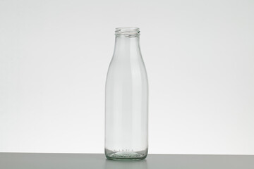 Empty glass bottle without cap. Bottle for milk and water isolated on white background.
