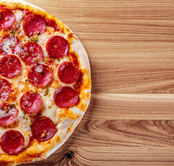 Pepperoni Pizza with cheese, salami, Tomato sauce, pepper, Spices. Italian pizza on wooden background