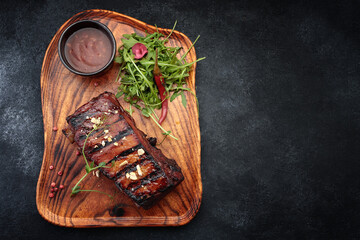 Grilled ribs with sauce on a wooden board
