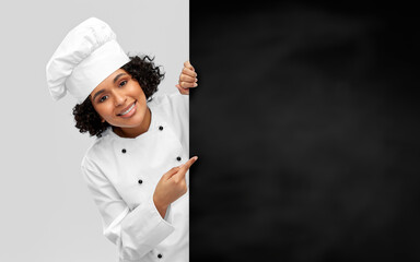 cooking, advertisement and people concept - happy smiling female chef in toque with black...