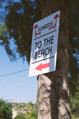 Signboard with a red arrow and an inscription "Sunbeds. To the Beach" side view (Rhodes, Greece)