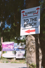 Road sign indicating the direction to the beach with the inscription "Sunbeds. To the Beach" (Rhodes, Greece)