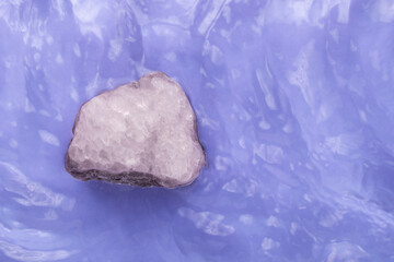 Salt crystal on blue calm water texture with splashes and waves.