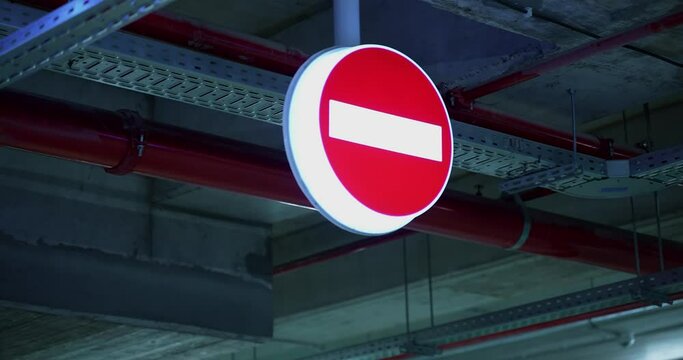a sign for the opposite direction of the vehicle placed hanging from the ceiling in the garage