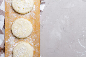 Raw cottage cheese pancakes on a wooden board. Healthy and delicious breakfast or lunch. Top view 