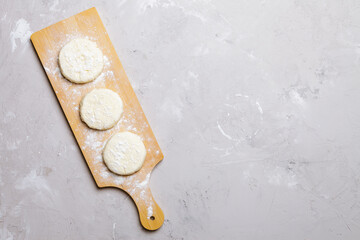 Raw cottage cheese pancakes on a wooden board. Healthy and delicious breakfast or lunch. Top view 