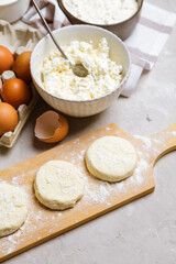 Raw cottage cheese pancakes on a wooden board. Healthy and delicious breakfast or lunch