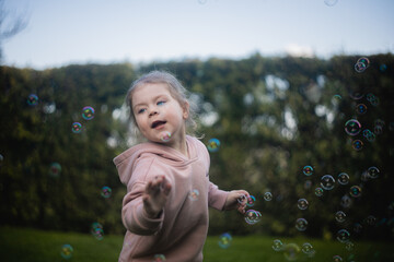 Dziewczynka bawi się bańkami na podwórku