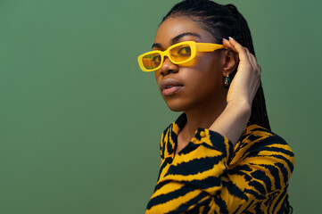 Fashionable confident Black woman wearing trendy yellow rectangle sunglasses, animal, tiger print...