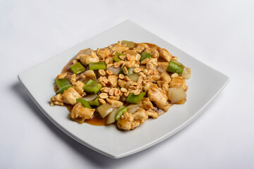 Chess chicken with green peppers, onions and peanuts in white plate isolated. Chinese traditional food.