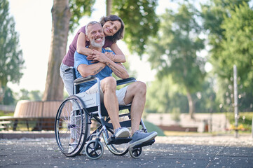 A woman and a man in a wheel chair feeling happy and smiling