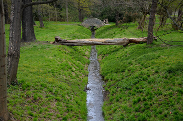arch bridge, stone granite with railings to the arch. english landscape park. the grassy ditch of...
