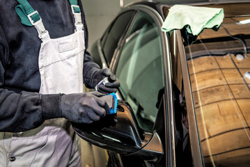 Car service worker applying nano coating on a car detail.