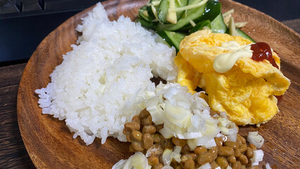 朝食。ワンプレートにご飯、納豆、つけもの、オムレツ