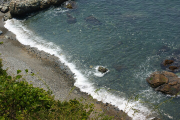 There are white bubbles along the coastline and waves.
