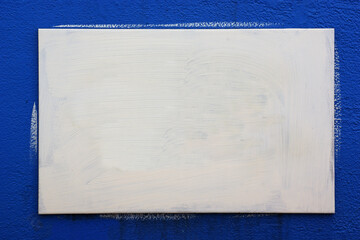 a white-painted wooden board against a blue background
