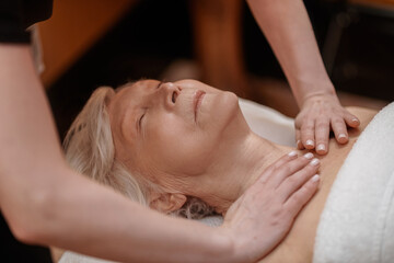 Obraz na płótnie Canvas A senior woman having an anti-age massage in a beauty salon