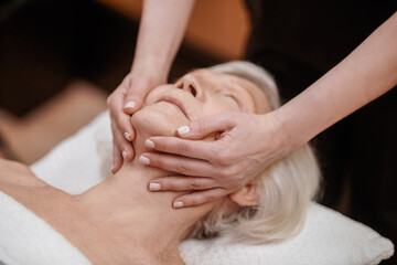 Fototapeta na wymiar A senior woman having an anti-age massage in a beauty salon