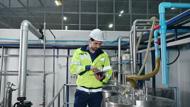 Mechanical Engineer With Tablet Checking Condition Of Storage Tank And Pipeline For Observe Abnormal Operating Status In Beverage Production Plant