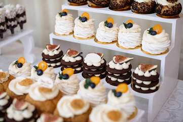 Various desserts and cake on the buffet table at the wedding - 500929680
