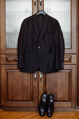 Stylish groom's jacket hangs on the closet in the morning on the wedding day