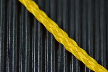 closeup photo of yellow plastic cord on black background